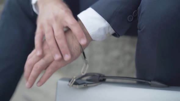 Close-up of Male Hand Chained To Attache Case with Handcuffs. Unrecognizable Secret Agent with