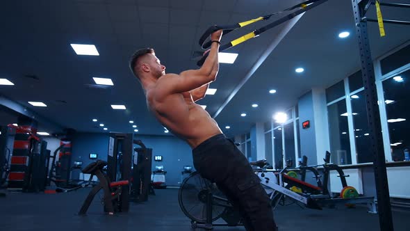 Fit Athlete Working Out. Young handsome man doing exercises in the gym