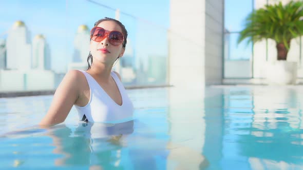 Young asian woman enjoy around outdoor swimming pool for leisure