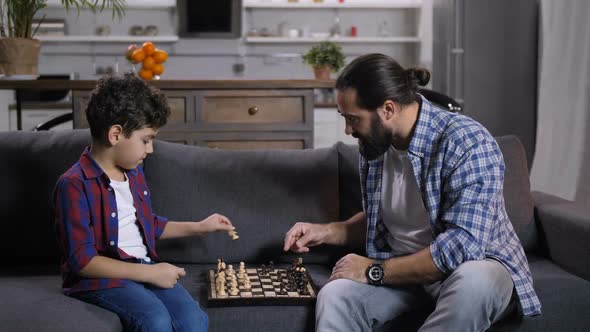 Inetelligent Father Teaching Son To Play Chess