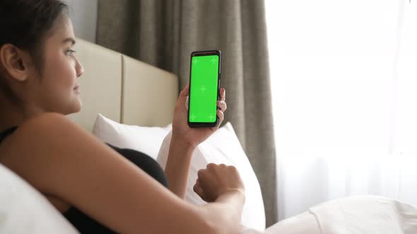 Woman In Bed Using Mobile Phone With Green Screen Chroma Key