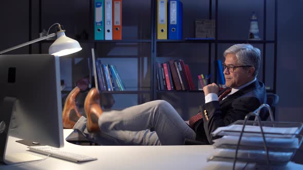 Businessman laughing at work desk