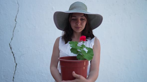 Front View Beautiful Young Woman with Red Flower in Brown Pot Looking at Camera Smiling