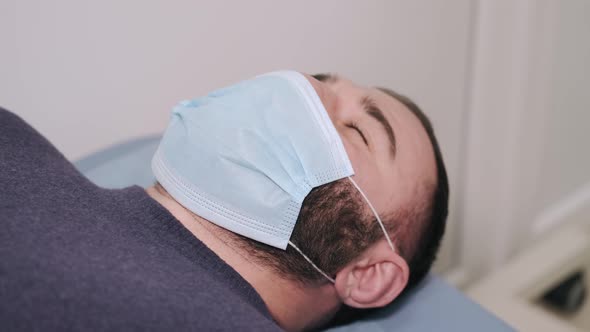 Man Laying at Doctor's Office Being Medically Scanned