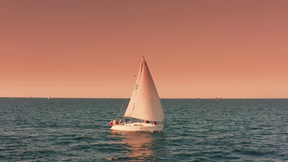 Evening Seascape with a Yacht with White Sails in the Open Sea