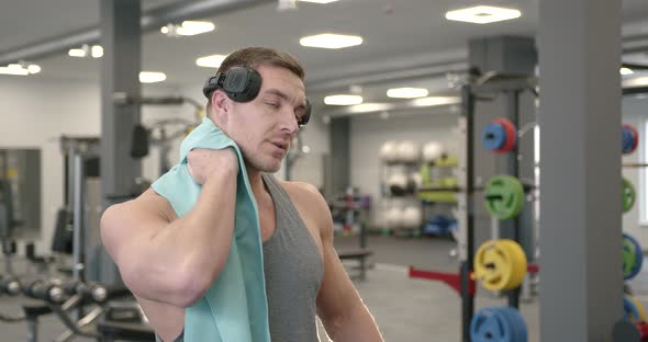 Exhausted Athletic Man Cleaning Sweat in a Gym