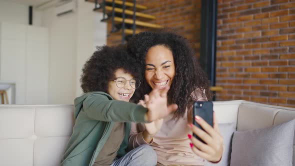 Mixed Race Mother and Son are Talking and Smiling Making a Video Call with Someone Using Smartphone