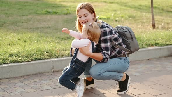 Mother and Little Daughter Are Having Fun in the Park in Sunny Weather