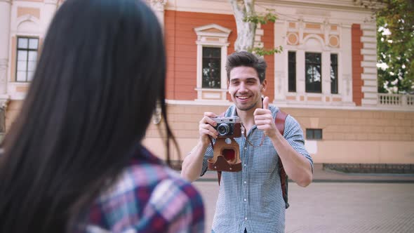 Young Mixed Race Tourist Couple Taking Pictures on Vintage Camera While Walking Through the City