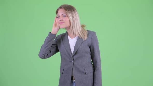 Happy Young Blonde Businesswoman Listening and Getting Good News