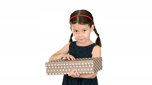 Happy Girl in Black Dress Shaking and Opening Gift Box Smiling at Camera on White Background.