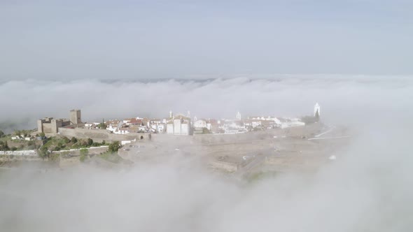 Aerial drone view of Monsaraz on the clouds in Alentejo, Portugal