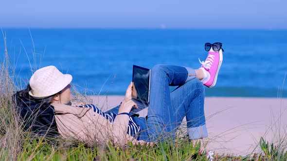 Woman Lying on Sand and Chatting Online on Beach