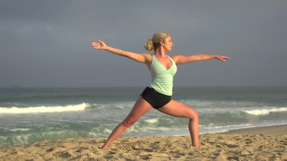 A young attractive woman doing yoga on the beach.