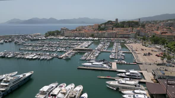 Drone flying over port in Cannes towards the old town, France