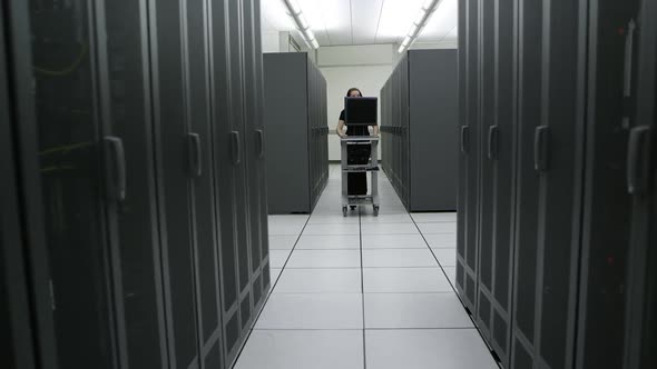 Dolly shot of server room as woman walks towards