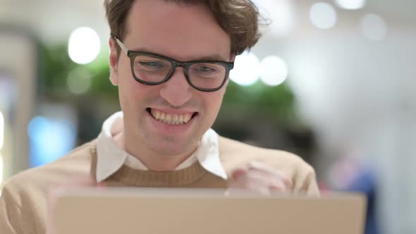 Close Up of Man Celebrating Success on Laptop