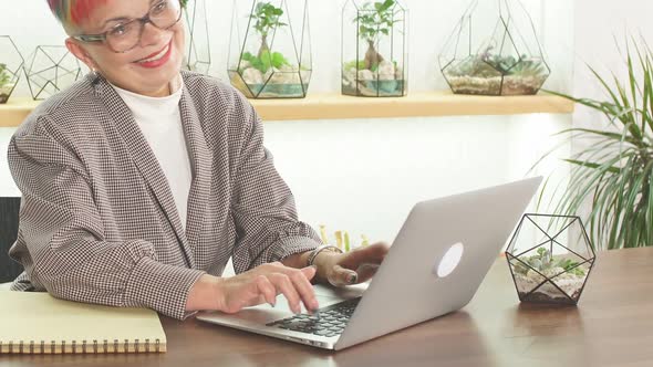 Mature Modern Business Lady Looking at Screen of Laptop, Smile While Typing To Colleague