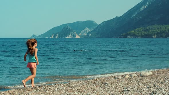 Young Girl Running Along Beach of Sea. Teenager Enjoying Holidays on Sea