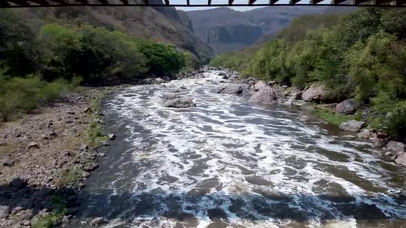 Aerial drone flying under a bridge in a canyon in the Barranca de Huentitan National Park in Mexico