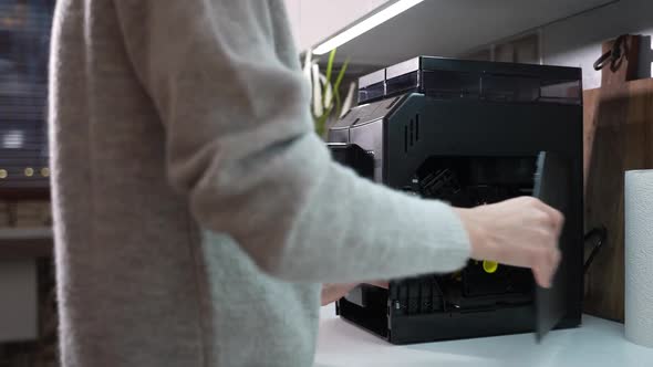 Woman Removes a Coffee Machine Brewing Unit to Clean It