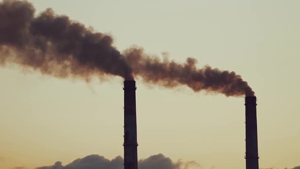 Large industrial pipes pollute the atmosphere with smoke.