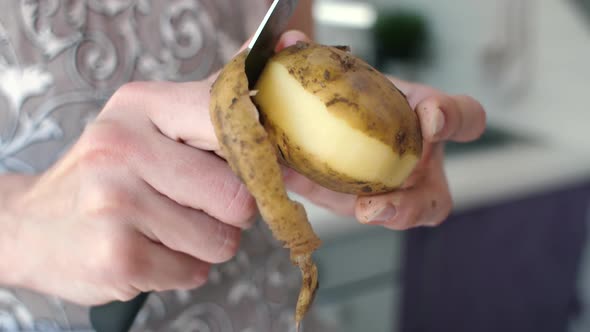 Hands Peeling Potatoes at Kitchen