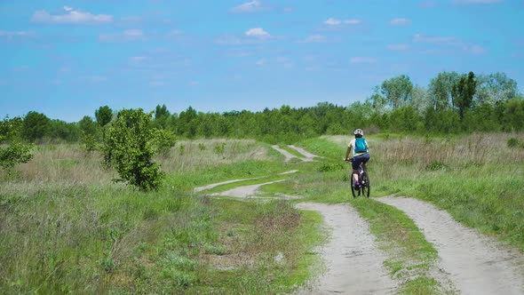 Woman Cyclist Moving On Bike On Countryside