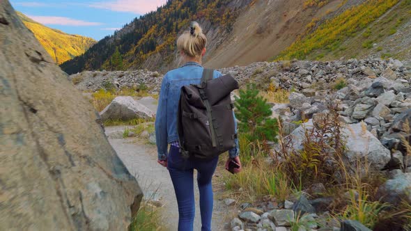 A young beautiful slender woman alone in the mountains.