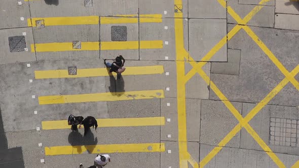 People crossing the yellow pedestrian crossing in Hong Kong - top view