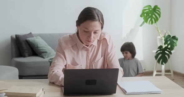 Young Focused Woman Working Remotely on Laptop