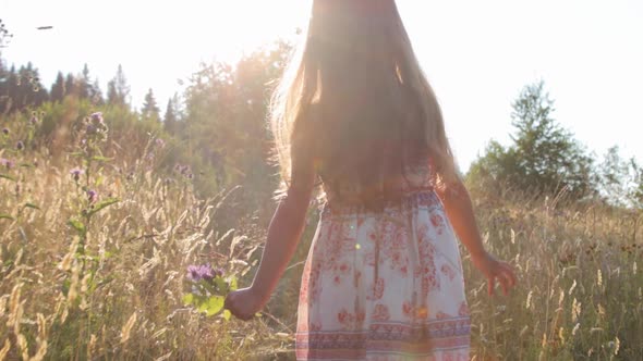 Little girl walking through summer field