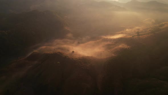 4K Aerial view from drone over mountains fog. Golden scenery at sunrise, Nan, Thailand