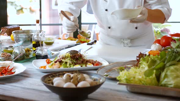 Spoon Pours Liquid Onto Salad.