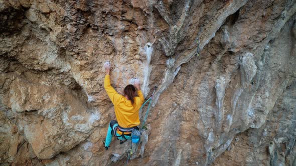 Skilful Athletic Male Rock Climber Resting While Climbs on Overhanging Rock Cliff