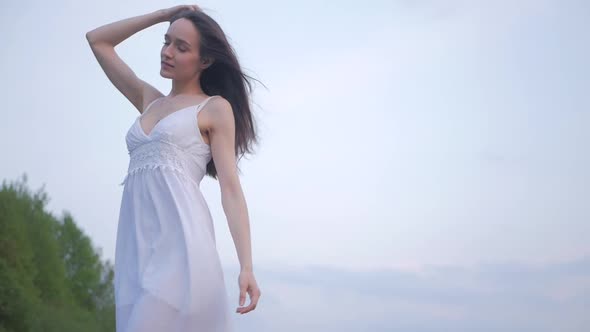 tender sensual spring fashion portrait of a beautiful happy young woman in white dress with long bro
