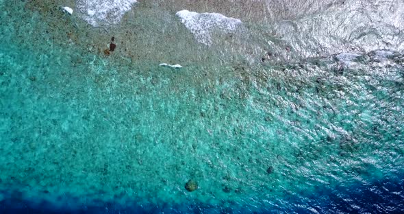 Wide drone tourism shot of a white paradise beach and aqua blue water background