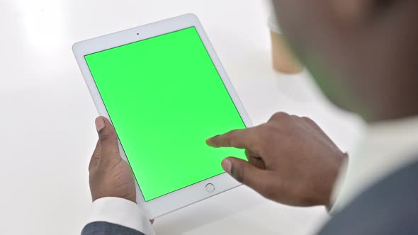 Rear View of African Man Using Tablet with Chroma Key Screen