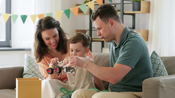 Happy Family Playing with Birthday Present at Home