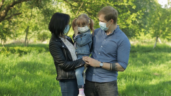 Family in Park Takes Off Medical Masks After Coronavirus Pandemic Quarantine End