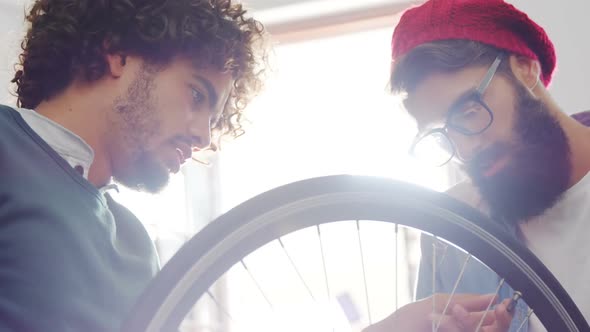 Mechanics repairing bicycle in workshop