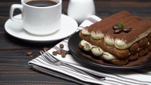 Classic Tiramisu Dessert on Ceramic Plate, Cream or Milk and Cup of Coffee on Wooden Background