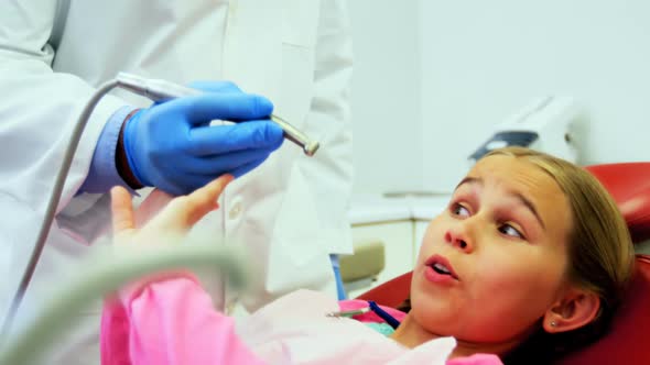 Girl stopping dentist for examining her in clinic