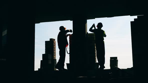 Workers Lay Bricks on a Sky Background