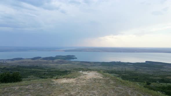 Copter Flies Over a Mountain with a Lake in Summer