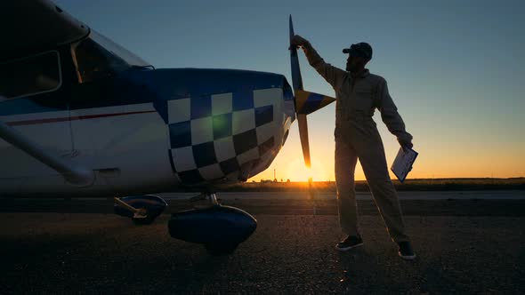 Sunset Take-off Runway with a Male Service Engineer Cleaning the Airplane