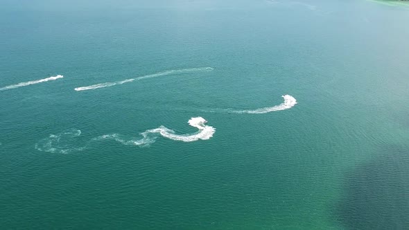 Aerial of Jet skis doing freestyle tricks in the sea. beautiful turquoise blue sea of Sao Beach, Phu