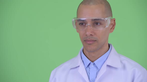 Face of Happy Bald Multi Ethnic Man Doctor with Protective Eyeglasses Thinking