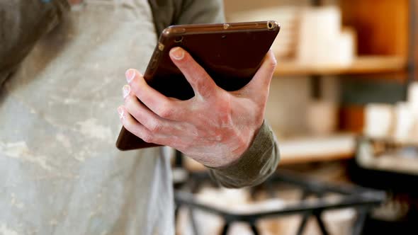 Potter using a digital tablet in workshop 4k