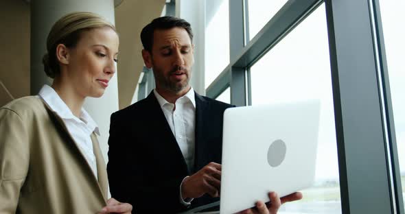 Businessman and woman discussing on laptop